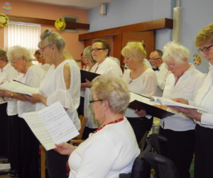 Women in white shirts singing in a choir