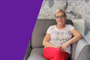 A purple graphic featuring an image of Annmarie Grimshaw, a support worker at Supported Living. Annmarie, with short blonde hair is sitting comfortably on a grey couch smiling.